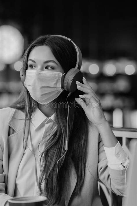 A Girl Sitting in a Coffee Shop with Headphones. Coronavirus Outbreak. Stock Image - Image of ...