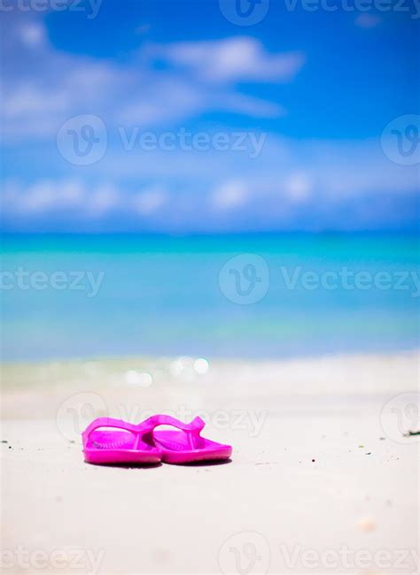 Pink vibrant beach flip flops on white sand on sea background 17758814 ...