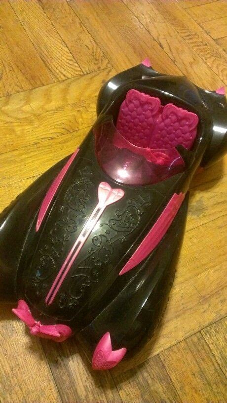 a black and pink toy car sitting on top of a wooden floor