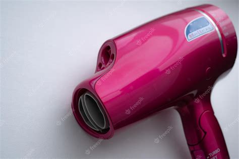 Premium Photo | Pink hair dryer and white background