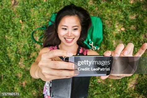 Woman Relaxed Taking A Selfie Laying Down In The Park High-Res Stock Photo - Getty Images