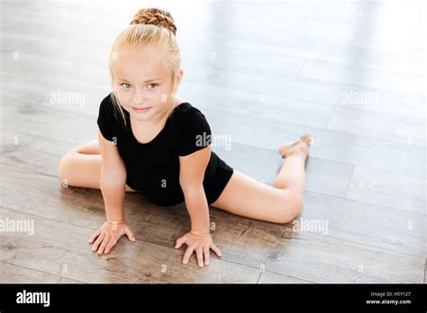 Cute little girl ballerina stretching on the floor in dance studio Stock Photo - Alamy