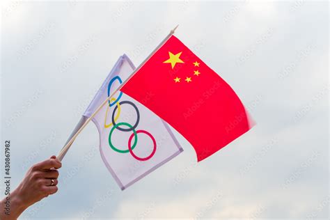 Fan waving the national flag of .China and the Olympic flag with symbol olympics rings. Stock ...