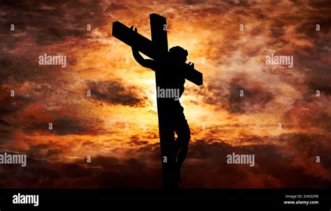 Jesus Christ crucified on the cross at Calvary hill with burning sky in ...