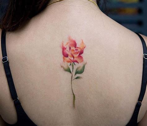 Burning flower watercolor spine tattoo by @georgiagreynyc.