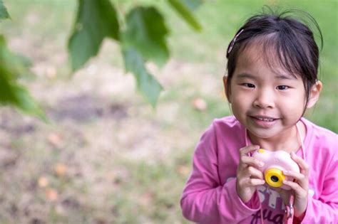 Premium Photo | Asian little girl holding a plastic camera toy