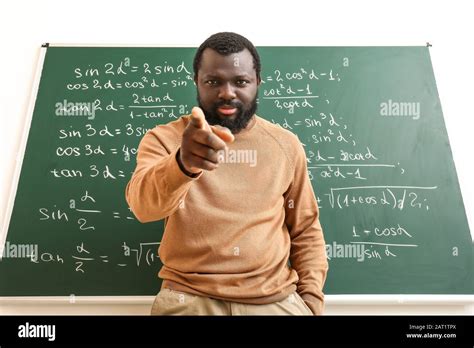 Angry African-American math teacher near blackboard in classroom Stock ...