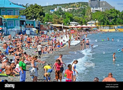 ALUSHTA, CRIMEA, UKRAINE - People on the public pebble beach near Black Sea in Alushta, Ukraine ...