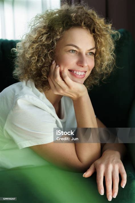 Beautiful Woman With Curly Hair Lying On Green Sofa Stock Photo ...