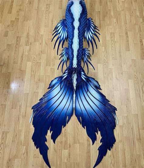 a blue and white dragon tail laying on top of a wooden floor