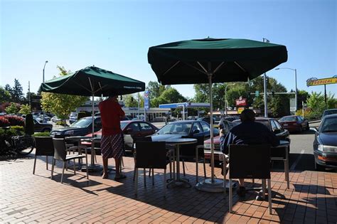 Breakfast with a newspaper and a smoke, Starbucks, patio, umbrellas, Lake City Parking lot, sun ...