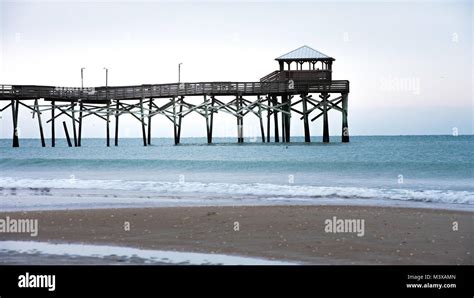 Sunrise with the Atlantic Beach pier in the background with sand, ocean ...