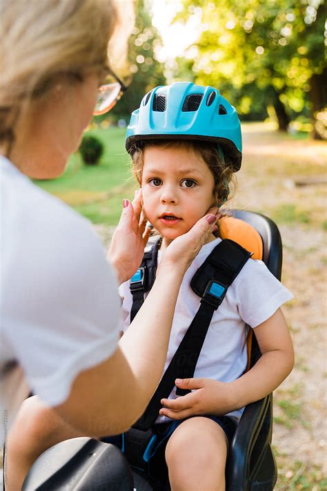 Mother putting on son's safety bike helmet - Stock Image - Everypixel