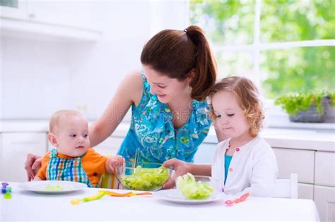 Mother And Children Cooking In A White Kitchen Stock Image - Image: 55784801