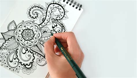 Person Holding Black Pen Sketching Flower · Free Stock Photo