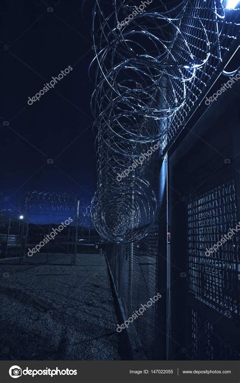 Prison Fence at night. Exterior barbed wire fence that the correctional ...