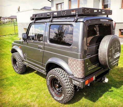 an suv parked in front of a house on the grass with its roof rack up