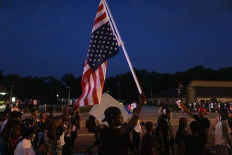 A man held an upside-down American flag during a protest. | Pictures of Protests in Ferguson, MO ...