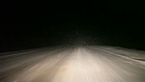 Vehicle Driving At Winter Night Road While Strong Snow Flying Towards ...