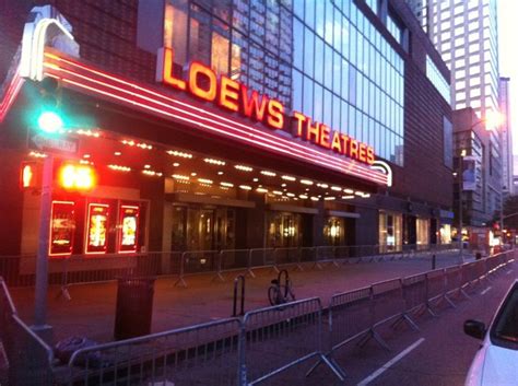 a view of the outside of a theatre from across the street, at night time