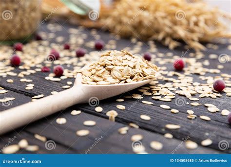 Rolled Oats or Oat Flakes on Wooden Spoon on Dark Wooden Background with Texture. Healthy ...