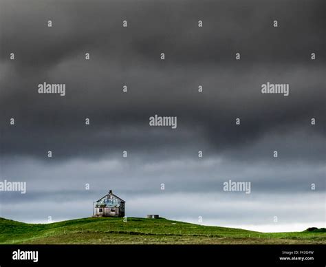 A barn on the crest of a hill, and dark storm clouds glowering over the land Stock Photo - Alamy