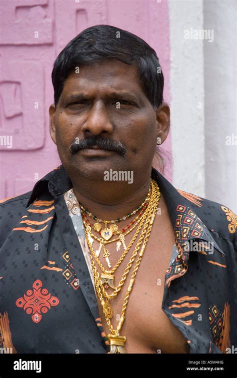 An Indian Malaysian making an ostentatious display of his wealth by wearing many gold chains ...