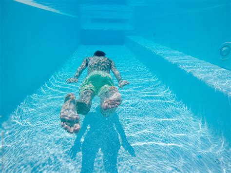 "Underwater Shot Of Man Floating In Swimming Pool" by Stocksy Contributor "Urs Siedentop & Co ...