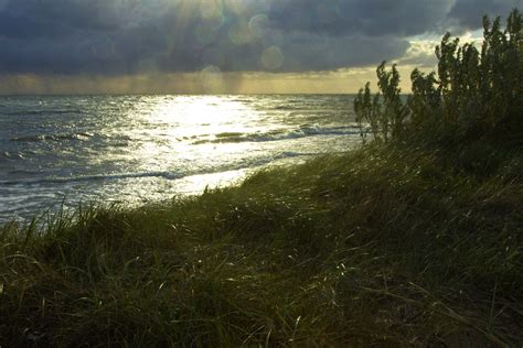 the sun shines brightly over the ocean on a cloudy day