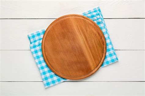 Premium Photo | Round wooden cutting board for pizza with blue plaid ...