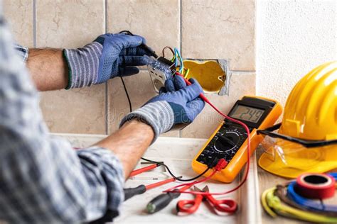 Electrician at Work with Safety Equipment on a Residential Electrical ...