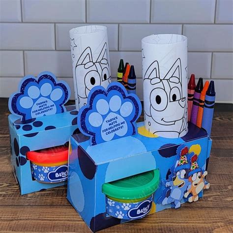 three boxes with markers and crayons in them sitting on a table next to each other