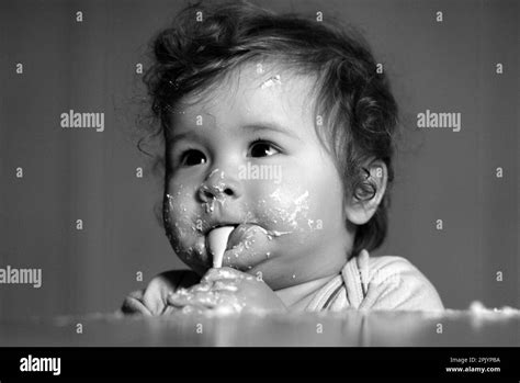 Kids baby eating with dirty face. Cheerful smiling child child eats ...