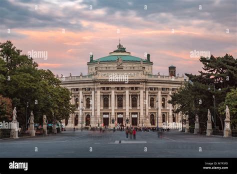 Long shot of Burgtheater in Vienna framed through the arch of Rathaus ...