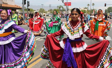 women in colorful dresses are dancing on the street