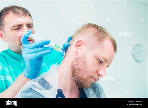 Close up Neurologist doctor makes an injection therapy (blockade) into head nape muscle of male ...