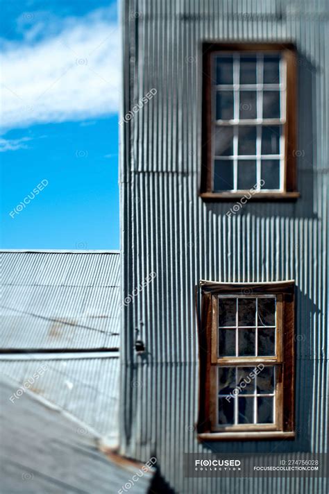 Windows in building wall with metal siding — architectural, decay ...