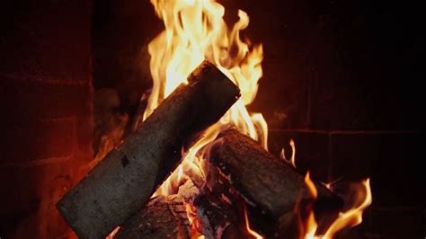 a fire burning in a fireplace with lots of logs sticking out of it's sides