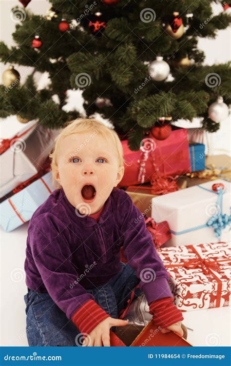 Christmas - Surprised Child Opening Gifts Stock Images - Image: 11984654