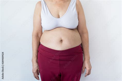 Overweight senior woman pinching her fat body,Cellulite around her belly button,Bloated belly ...