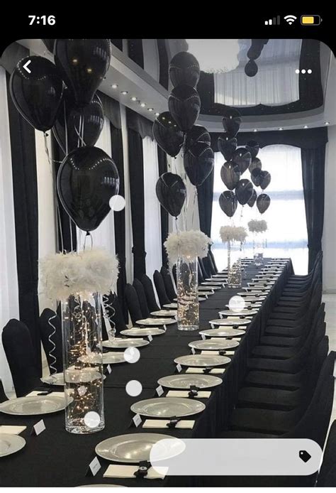 a long table with black and white decorations on it is set up for a party