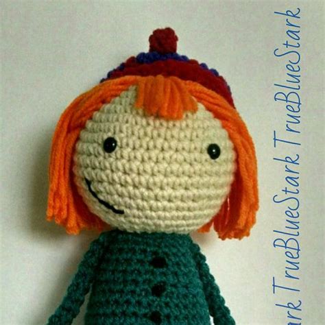 a crocheted doll with an orange hair and green dress is sitting on a ...