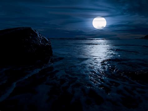 Premium Photo | Night time over the ocean with rock and full moon