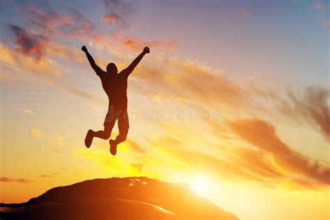 Happy Man Jumping For Joy On The Peak Of The Mountain At Sunset ...