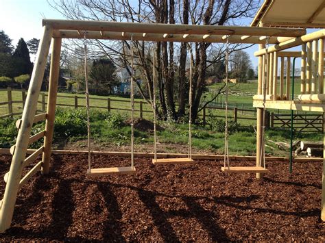 3 wooden swings engraved with each child's names - all hung below a ...