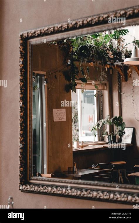 old clean mirror reflecting doorway into quiet coffee shop interior ...