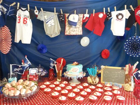 a table topped with cupcakes and cakes next to a blue wall covered in red, white and blue ...