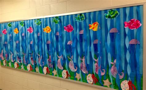 an art project is displayed on the wall in front of a school hallway with flowers and fish ...