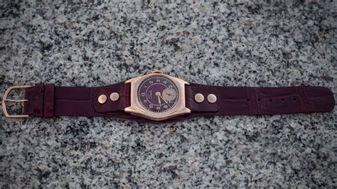 gold watch with a leather strap on Behance