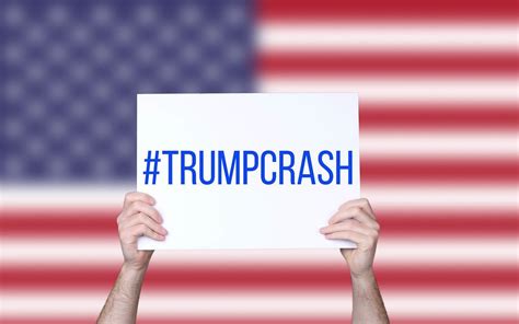 Hands holding board with #TrumpCrash text with USA flag background ...